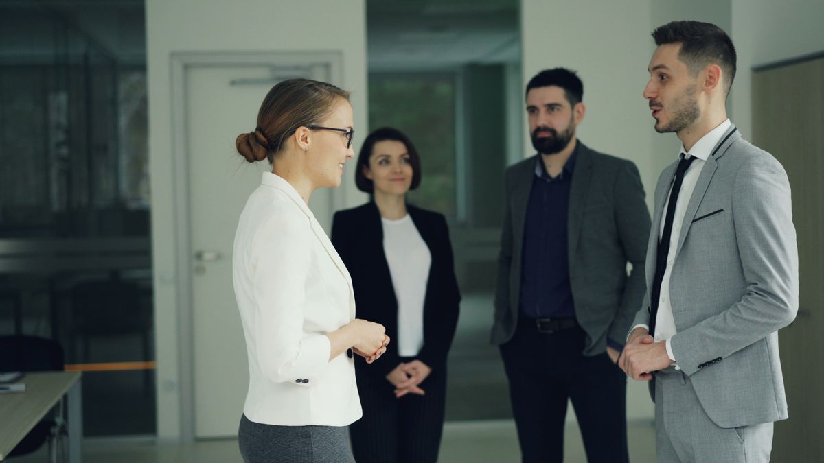 Group of professionals in formal attire having a discussion
