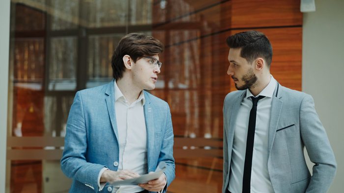 Two professionals having a conversation during a business meeting indoors
