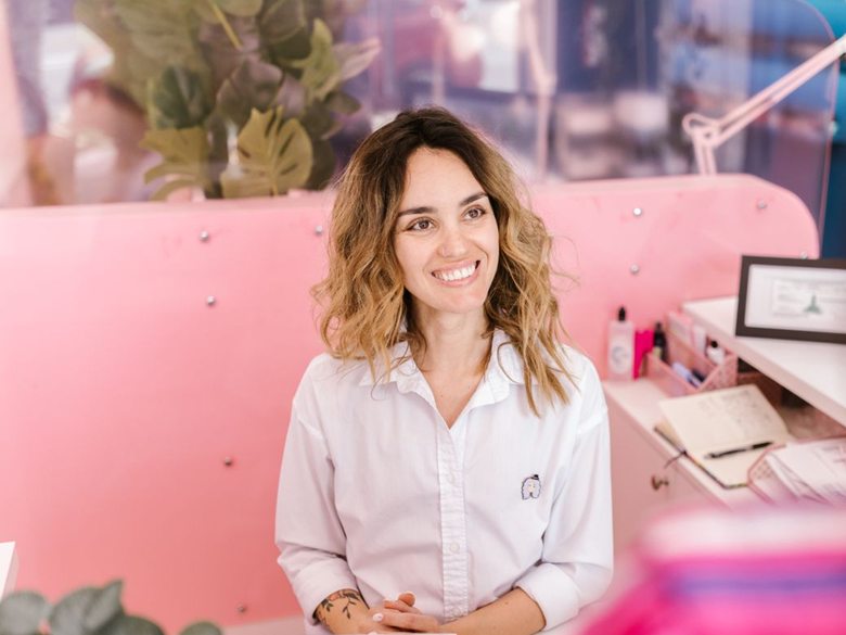 Smiling receptionist at a salon front desk