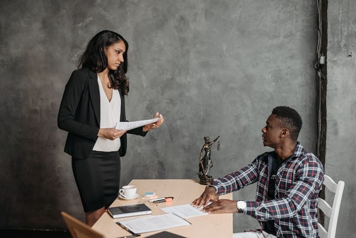 Two professionals engaged in a discussion over legal documents in an office setting