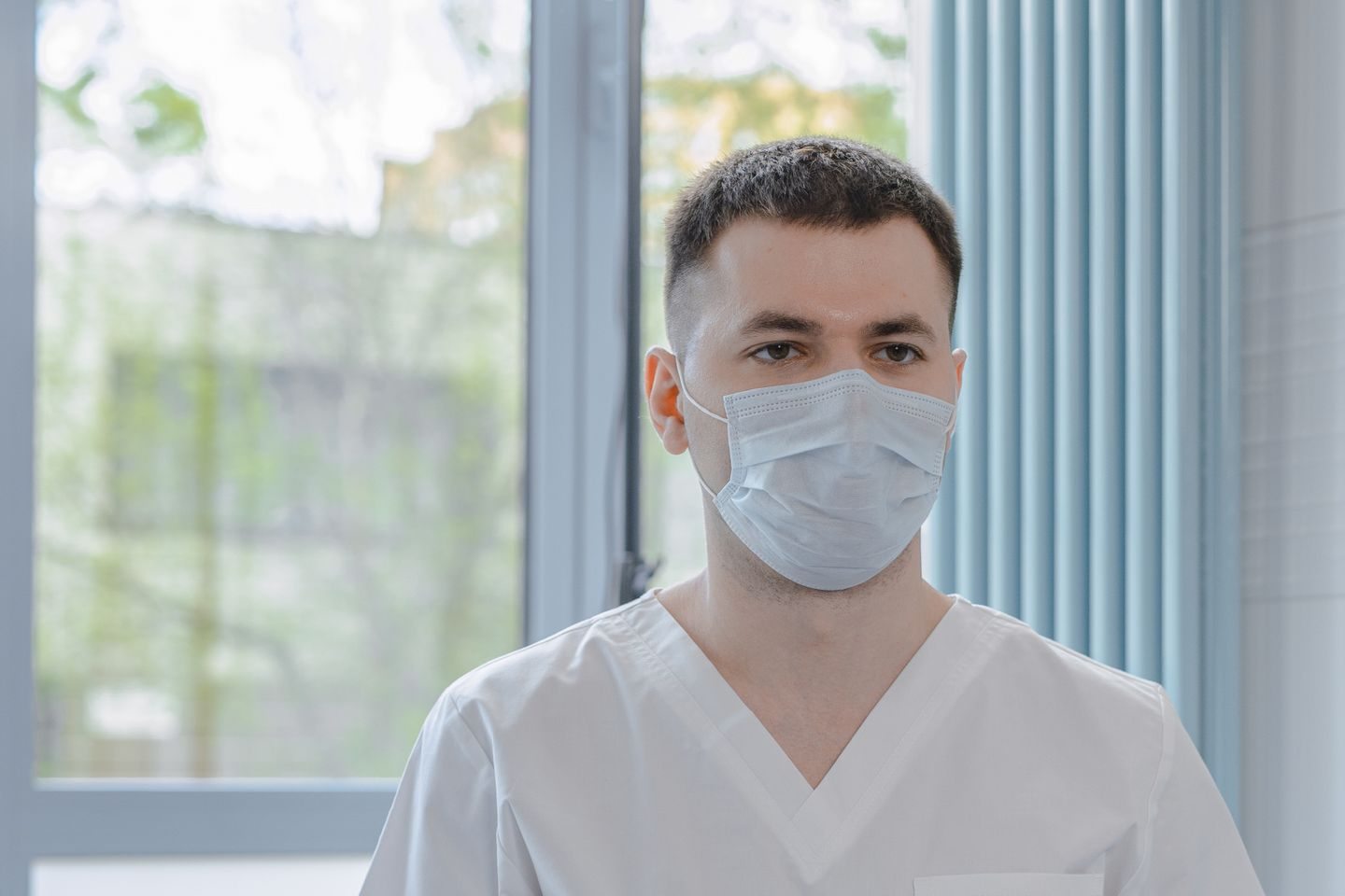 Medical professional in scrubs consulting with a patient while taking notes