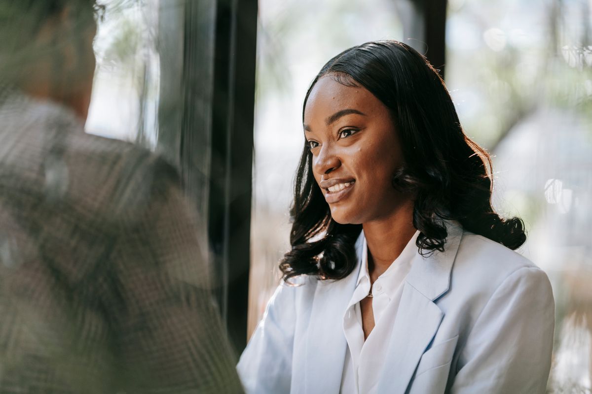 Professional black woman in business attire smiling during a meeting